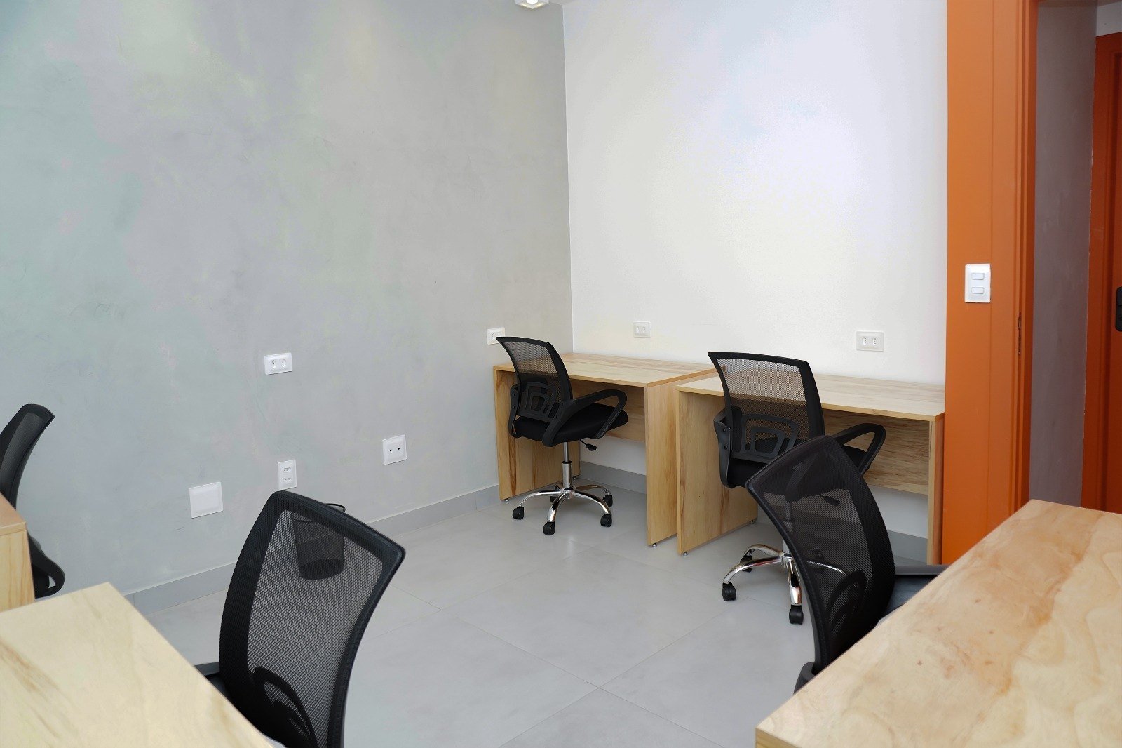 Sala compartilhada com estações de trabalho prontas